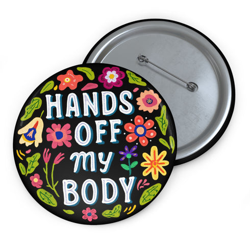 Glossy black pinback button with floral art and bold white text that reads “Hands Off My Body.” Feminist political button featuring bright pastel flowers in pink, red, orange, and yellow. Metal pin with durable safety pin back, shown in various settings: held by hand, displayed on pedestal, and against colorful street art. Available in 2" and 3" sizes, perfect for backpacks, jackets, tote bags, or as a gift for feminist allies and book lovers.